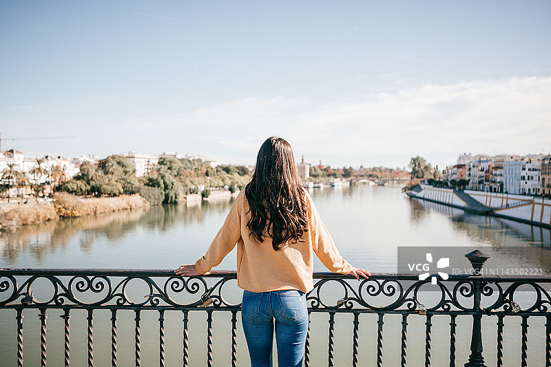 在塞维利亚观赏瓜达尔基维尔河的年轻游客图片素材