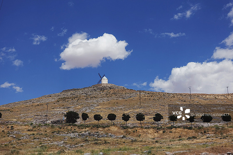 西班牙托莱多省孔苏埃格拉的著名风车和蓝天树木图片素材
