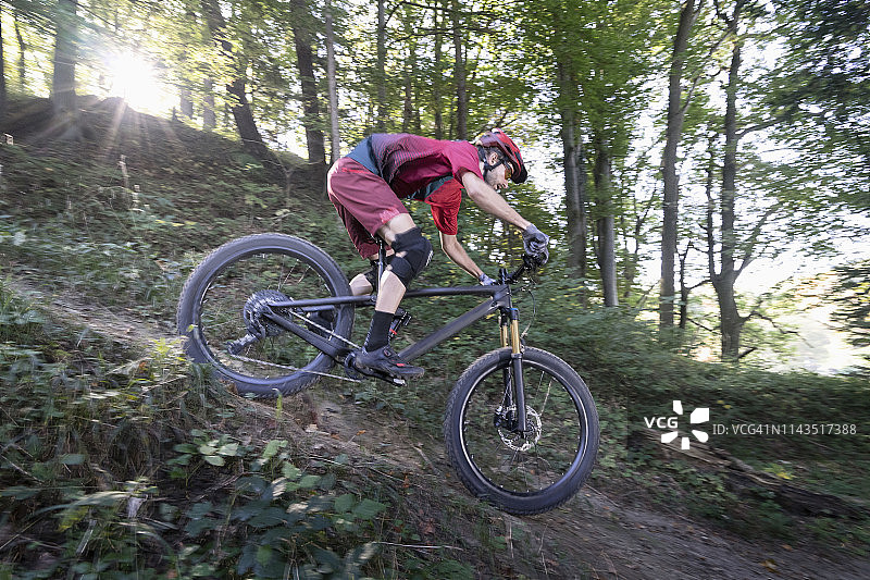 山地自行车手在德国巴伐利亚的森林赛道上骑下坡路图片素材