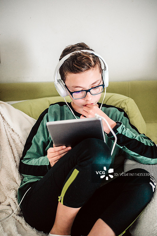 男孩在家使用平板电脑图片素材