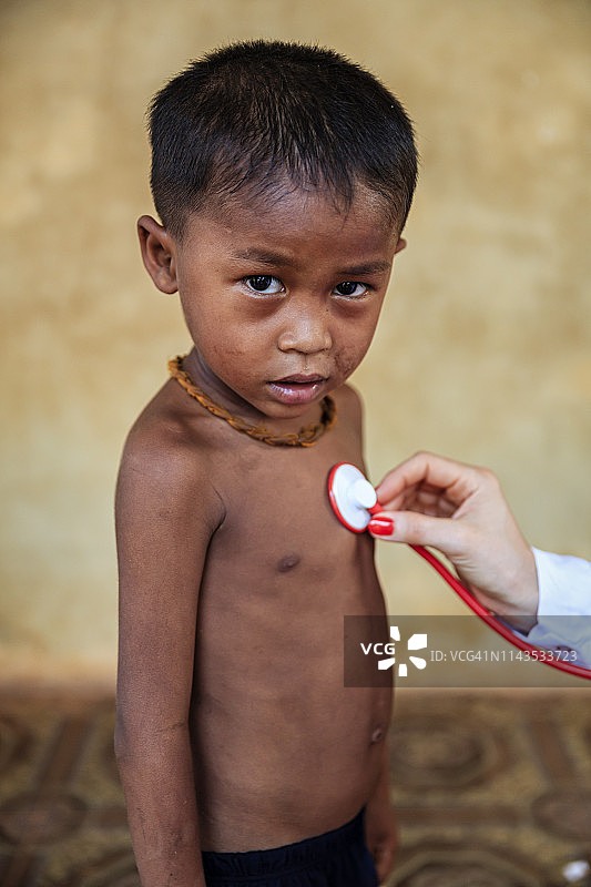 医生在柬埔寨洞里萨湖小村庄检查柬埔寨小男孩图片素材