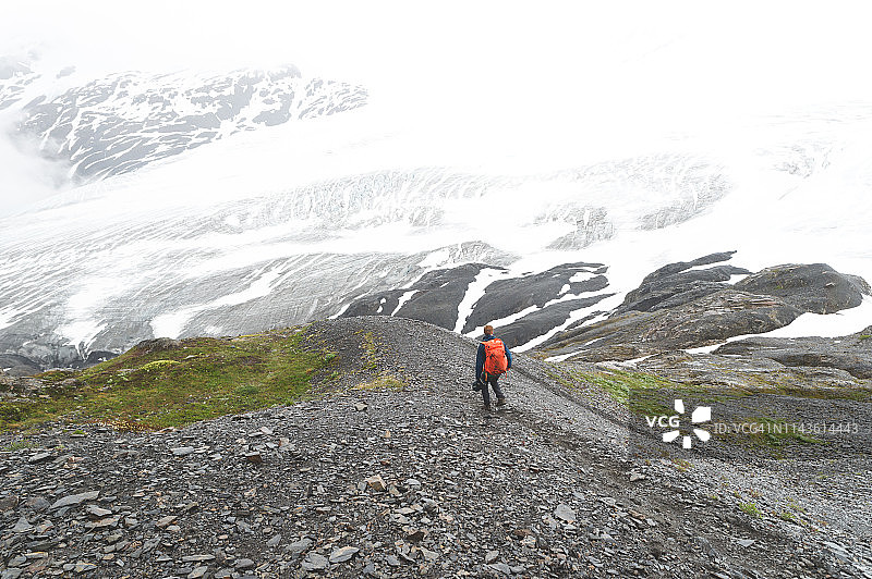 独自一人徒步攀登冰川的男人图片素材