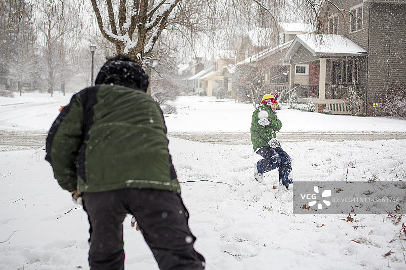 父亲在院子里和孩子打雪仗图片素材