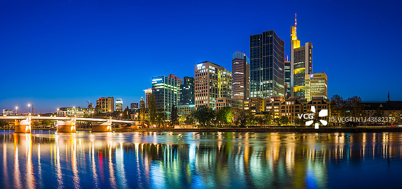 德国法兰克福，美因河上倒映着灯火通明的摩天大楼全景图片素材