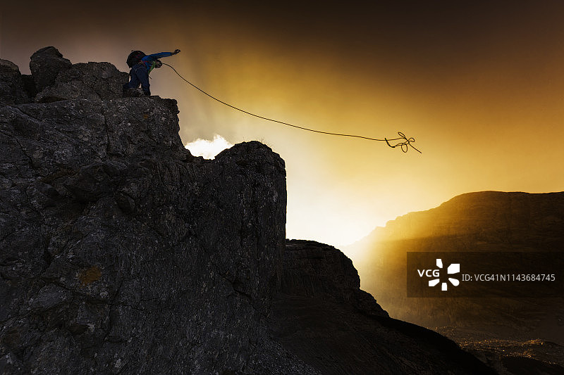 攀岩者在日落时抛绳图片素材