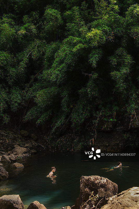 两个小男孩在竹林中的天然泳池游泳图片素材