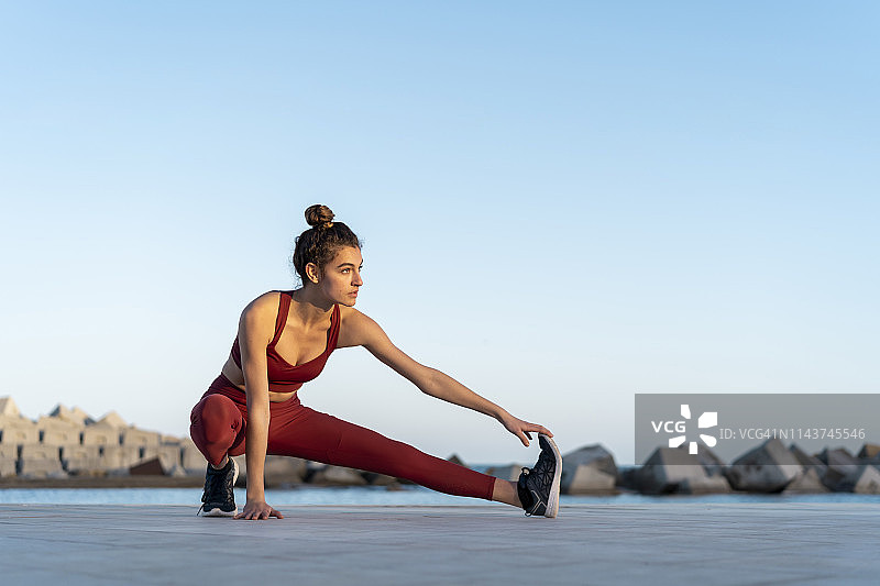 运动中的年轻女子伸展腿部图片素材