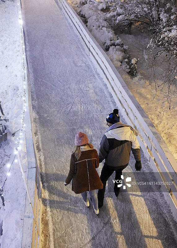 夜间，年轻情侣在溜冰场上的俯视图图片素材