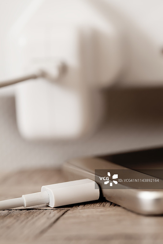 智能手机充电，背景是墙壁插座图片素材