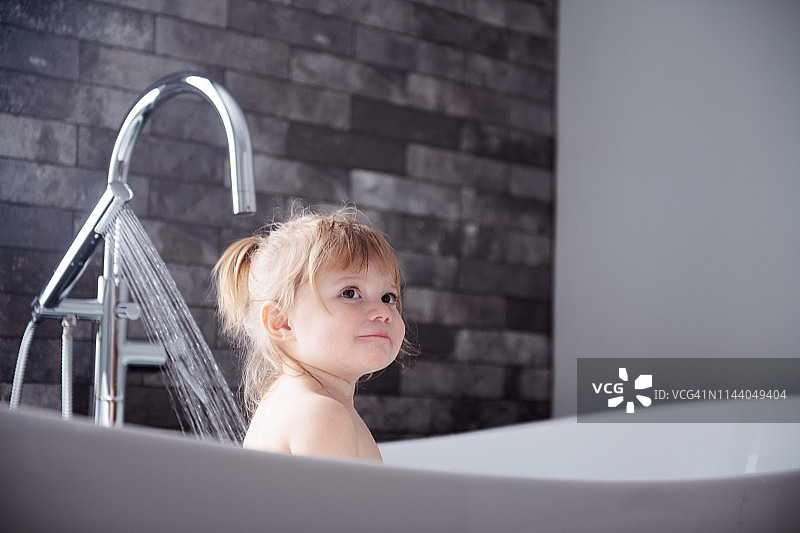 在浴缸里玩耍的可爱小女孩图片素材