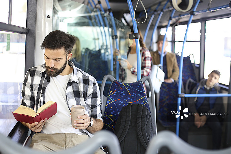 年轻人在公交车上看书图片素材