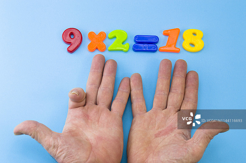 用手算九的乘法（9 * 2 = 18）图片素材