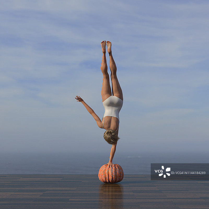 年轻女子在南瓜上练习倒立图片素材