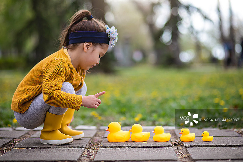 可爱女孩整理黄色玩具鸭家庭图片素材