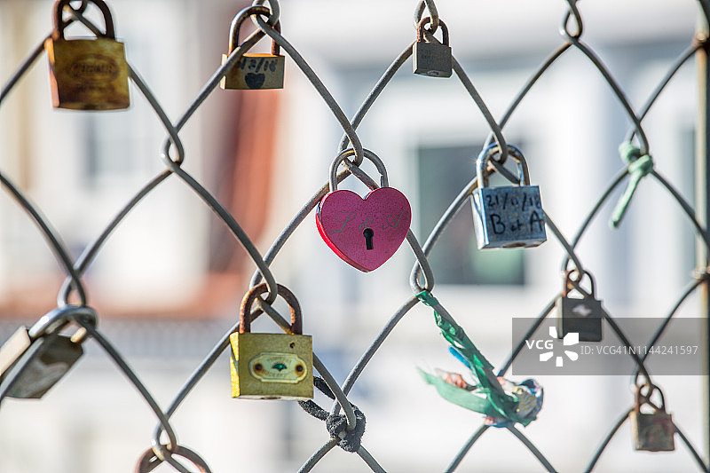 铁丝网上爱情锁的特写图片素材