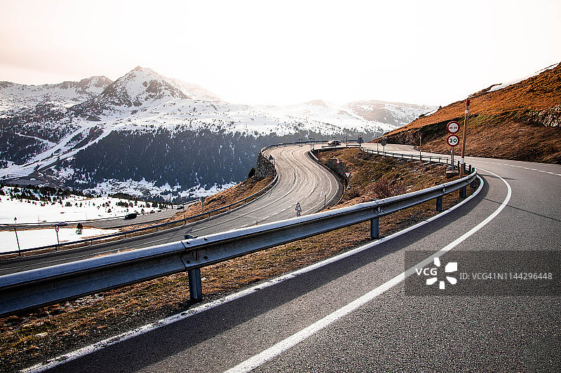 比利牛斯山脉迷人的山路弯道与雪峰图片素材