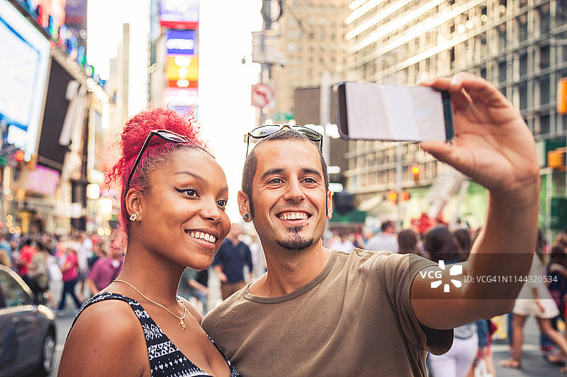 在纽约时代广场快乐的多文化情侣自拍图片素材