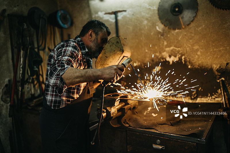 加工金属的老年男人图片素材