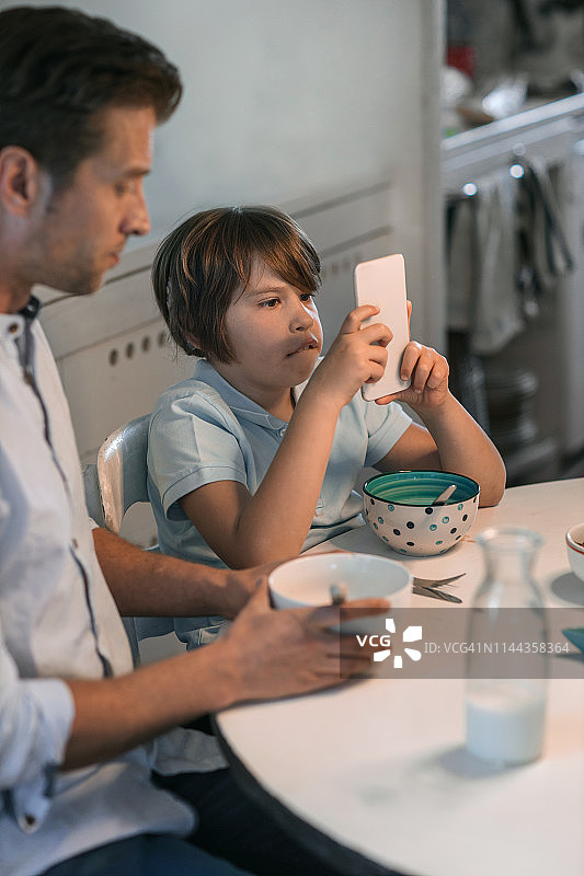 父子俩用耳蜗植入设备吃早餐图片素材