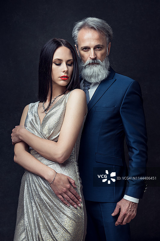 身穿长裙的优雅女性和穿着高级服装的老年男性肖像图片素材