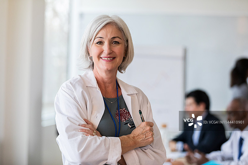 快乐的成熟女医生停下来拍照图片素材