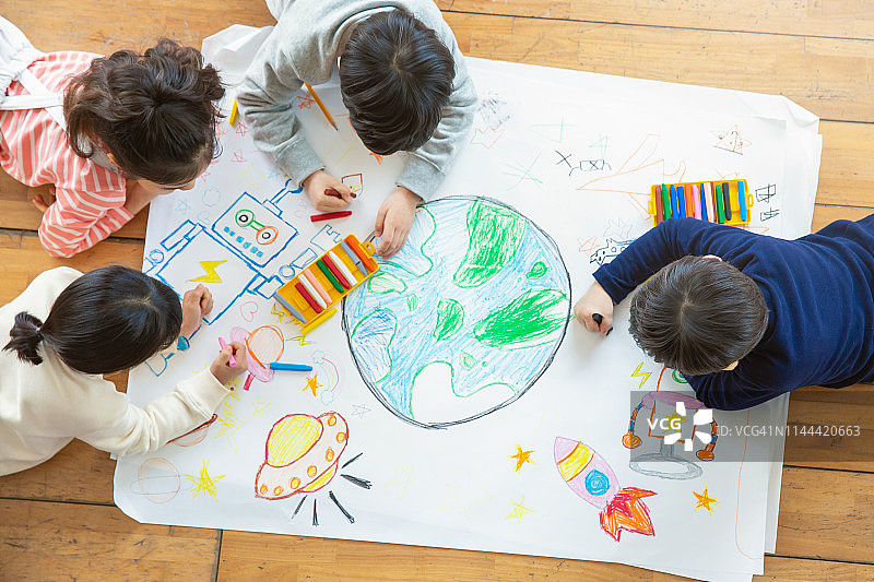 儿童用蜡笔在纸上绘画图片素材