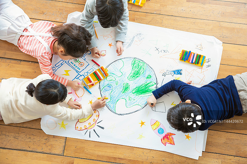 儿童用蜡笔在纸上绘画图片素材