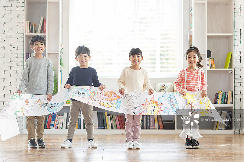 微笑的儿童拿着图画纸图片素材