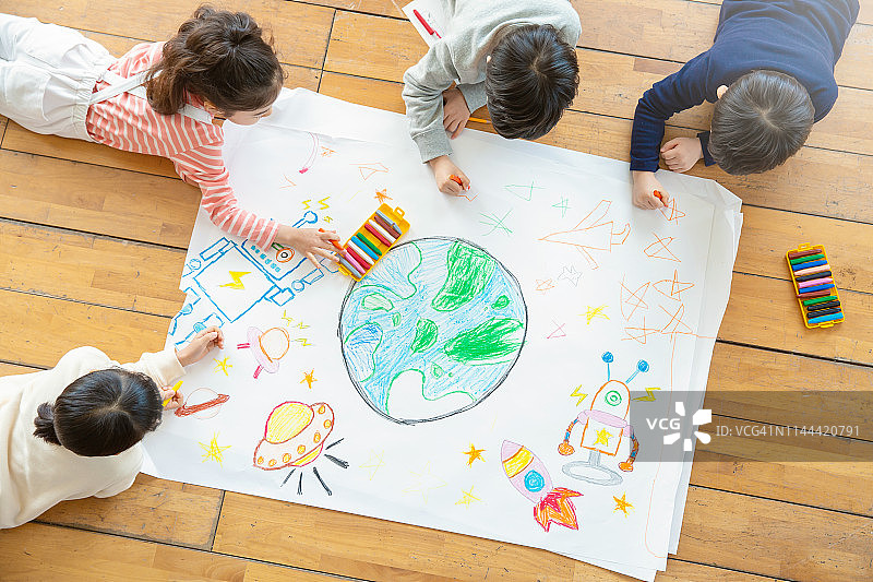 儿童用蜡笔在纸上绘画图片素材