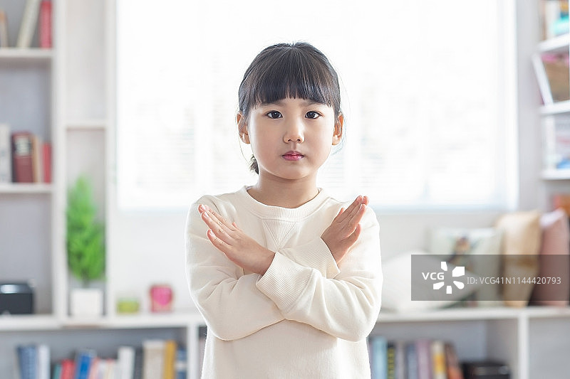 一个女孩用手比划“X”形手势图片素材