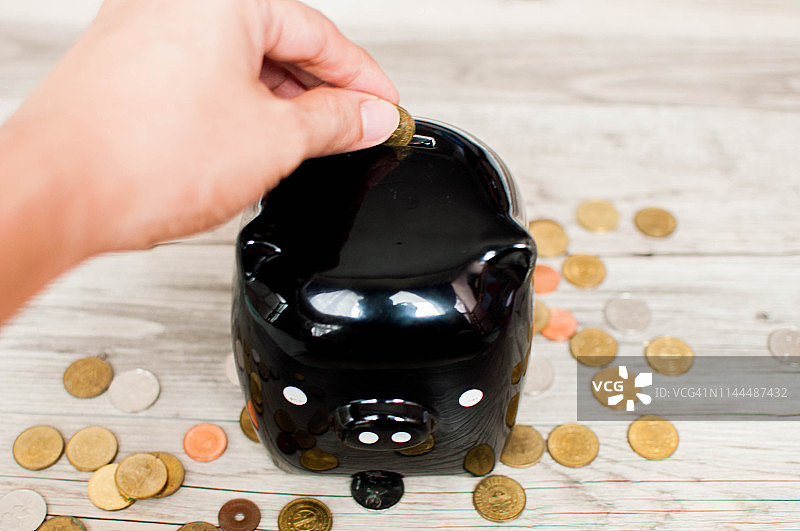 木桌上的黑色小猪储蓄罐俯视图图片素材