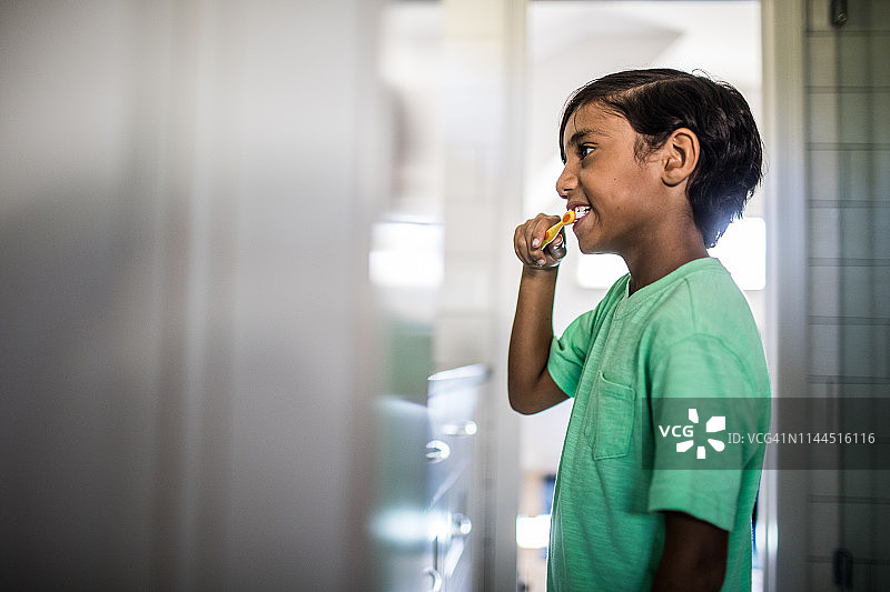 男孩在镜子里刷牙图片素材