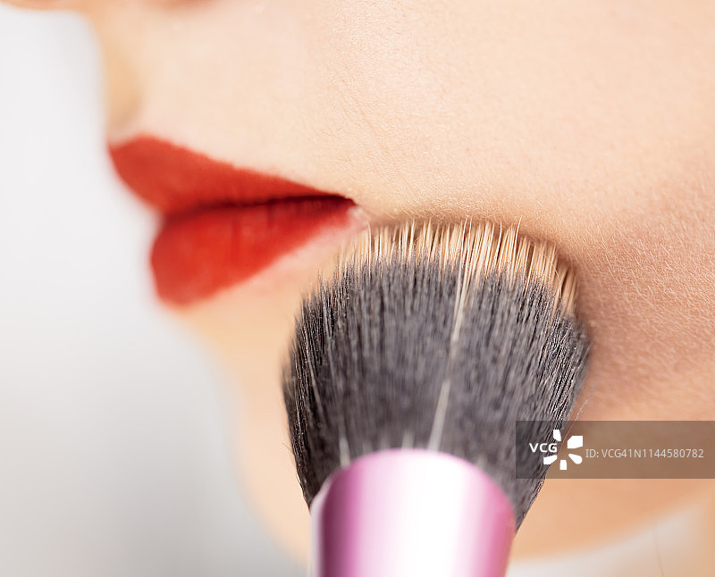 年轻女人涂腮红，面颊特写图片素材