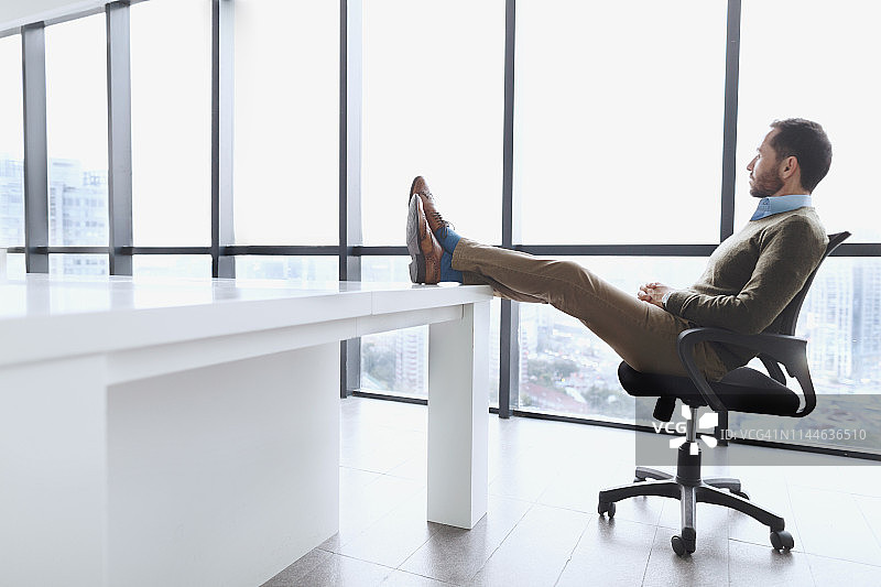 商人坐在桌子上看城市风景图片素材