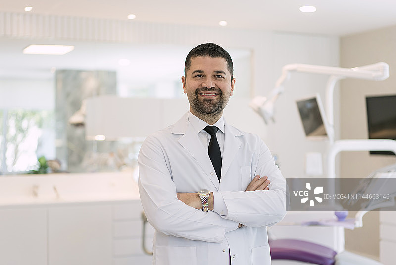 牙科诊所里微笑的男牙医图片素材