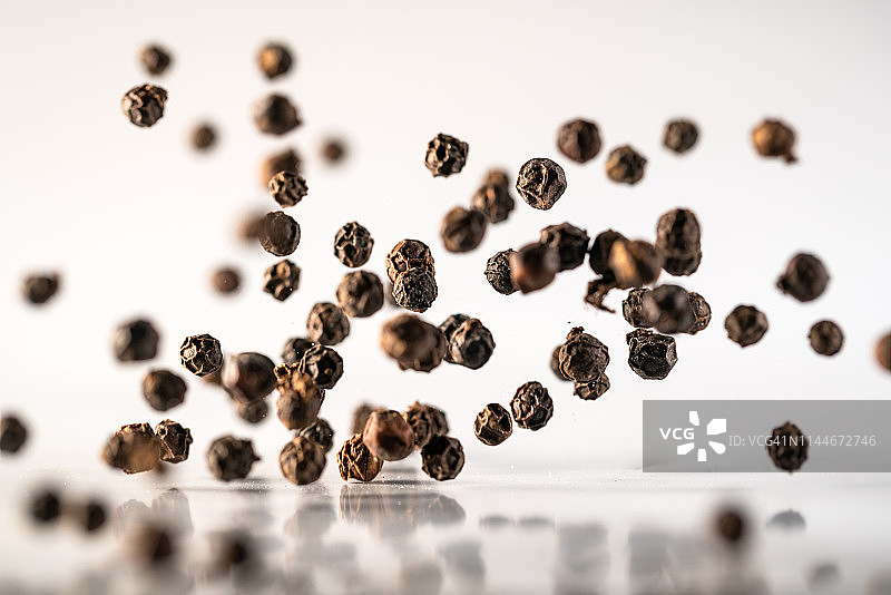 高速拍摄的白色背景上的黑胡椒粉图片素材