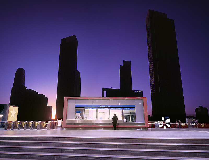 男人在日出时火车站服务亭购买车票图片素材