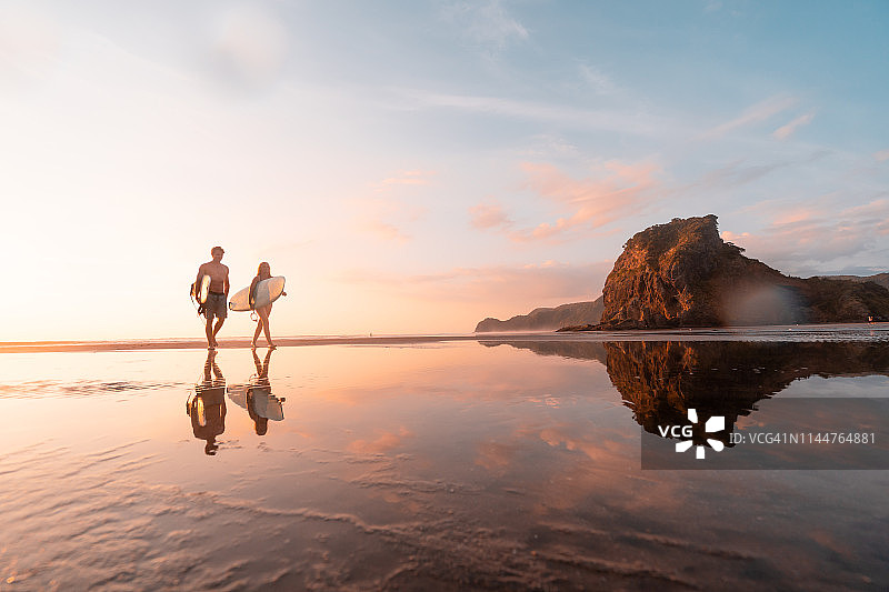 冲浪者在奥克兰Piha海滩回家图片素材