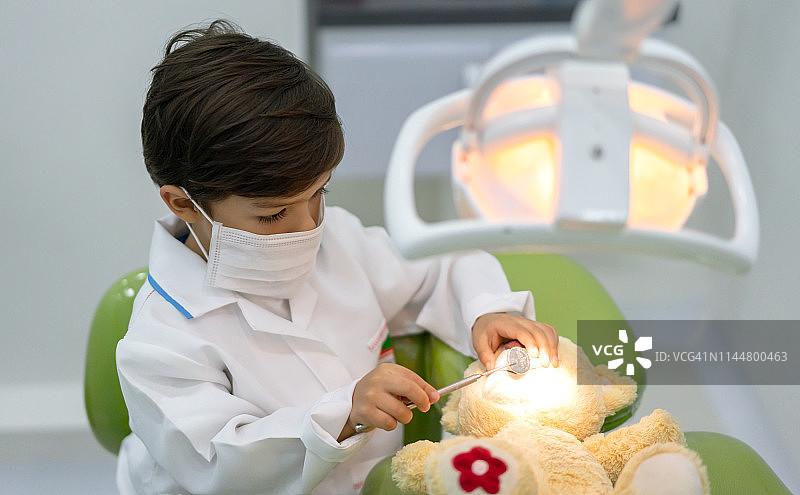 在牙医诊所玩耍的男孩和泰迪熊图片素材