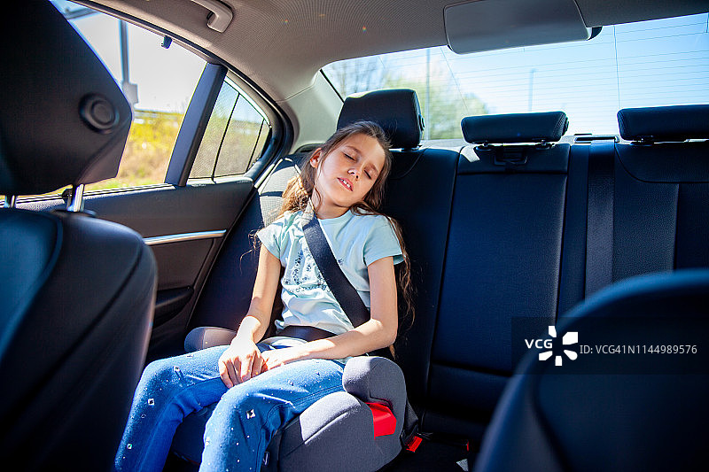 在车里不舒服地睡觉的小女孩图片素材