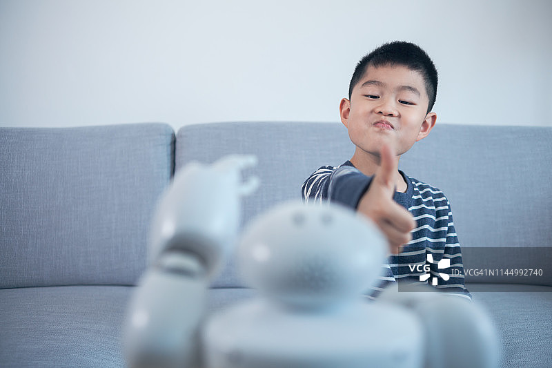在室内称赞机器人的睿智男孩图片素材