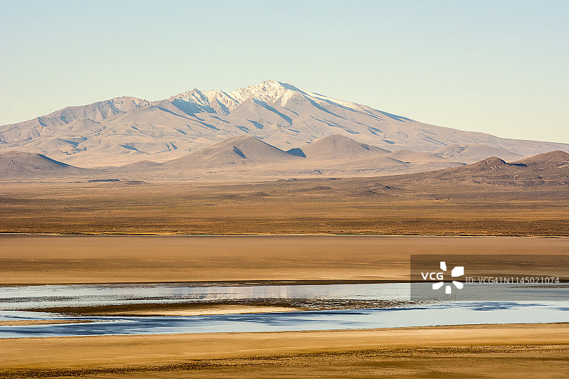 南美沙漠泻湖的傍晚景色，地平线上可见雪山图片素材