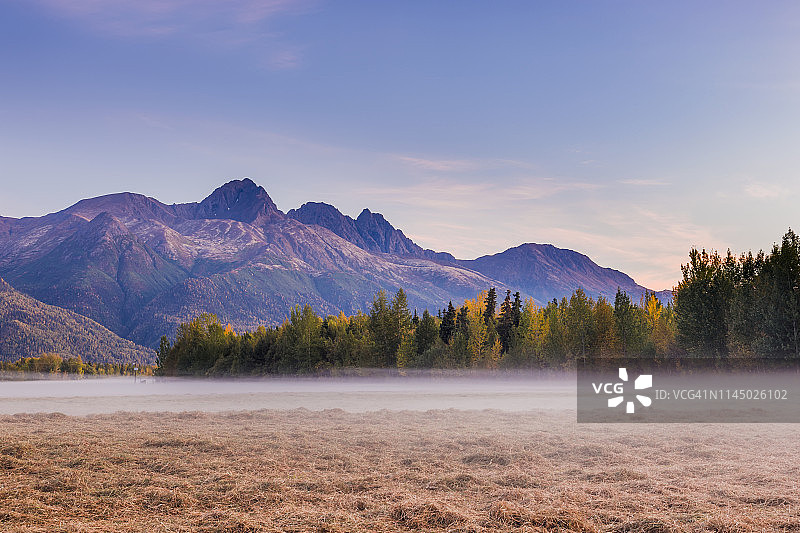 秋季，尼克河谷，阿拉斯加中南部，夕阳下的雾气笼罩着双峰和楚加奇山脉下的草地图片素材