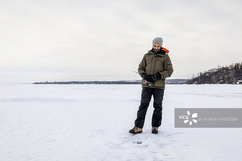 在瓦巴蒙湖冰钓时耐心等待鱼上钩的男人图片素材