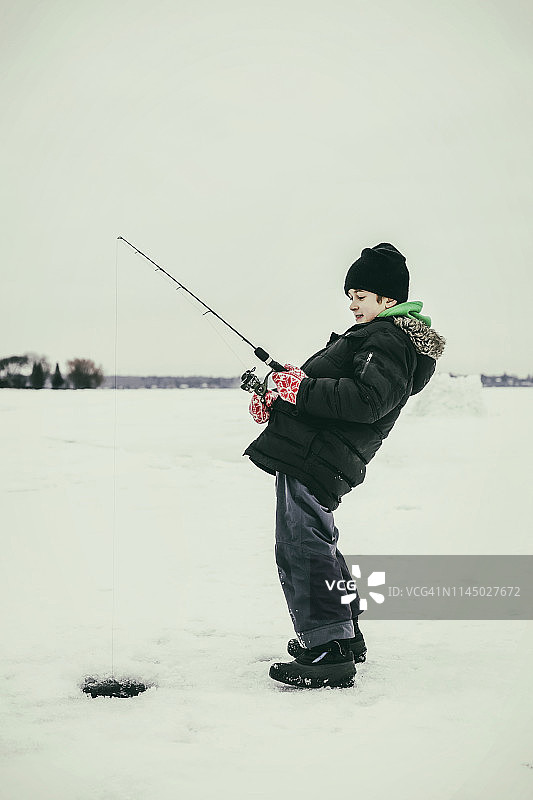 小男孩在瓦巴蒙湖冰钓，有鱼上钩了图片素材