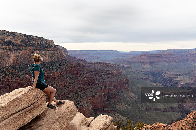 女人坐着俯瞰大峡谷南缘图片素材