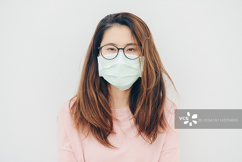 生病的亚洲女性的肖像，戴着口罩以防止传染病和流感图片素材