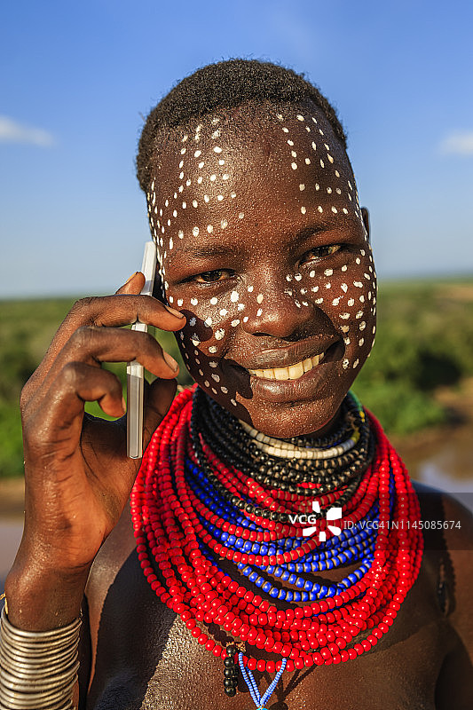 使用智能手机的卡罗部落年轻女孩，埃塞俄比亚，非洲图片素材