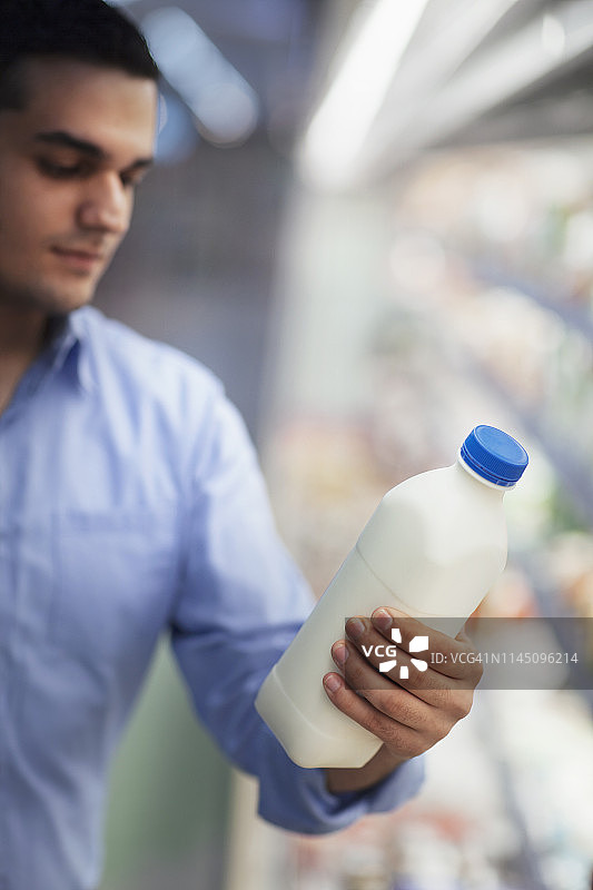 男人在超市手持牛奶盒图片素材