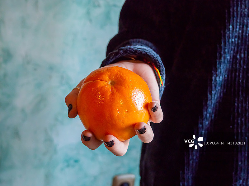 一人手拿一个橙子图片素材